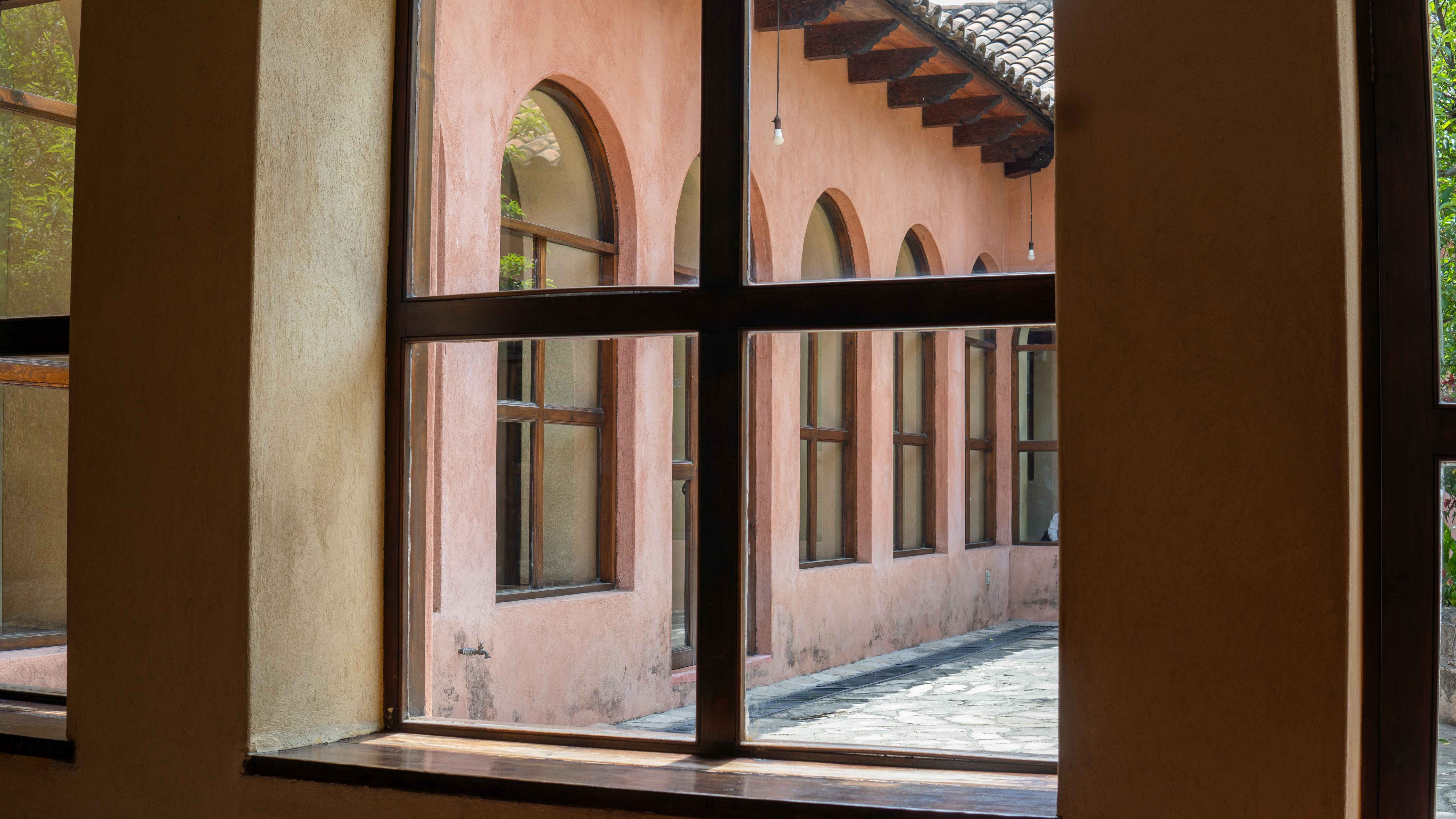 Patio interior de la clínica Esquipulas visto a través de una ventana.